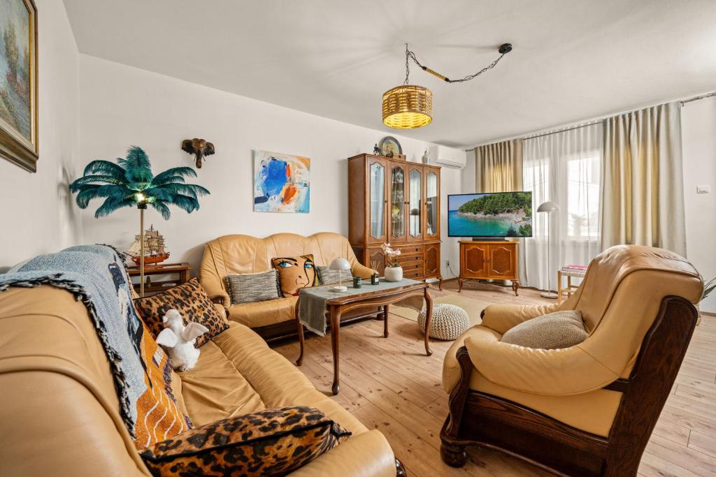 a living room with couches and a table at Gortanova Bay Maisonette in Pula