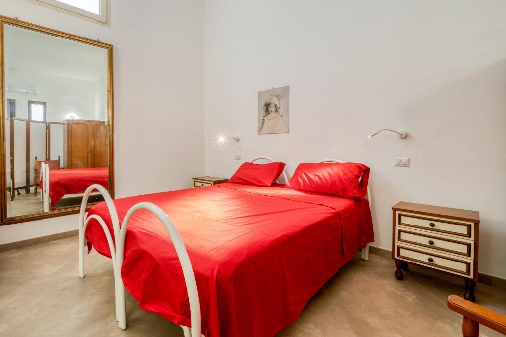 ein Schlafzimmer mit einem roten Bett und einem Spiegel in der Unterkunft Monolocale Volta in Nardò