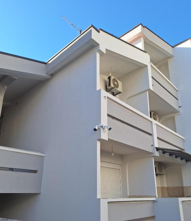 a white apartment building with a white door at Apartmani Miladinović in Sutomore