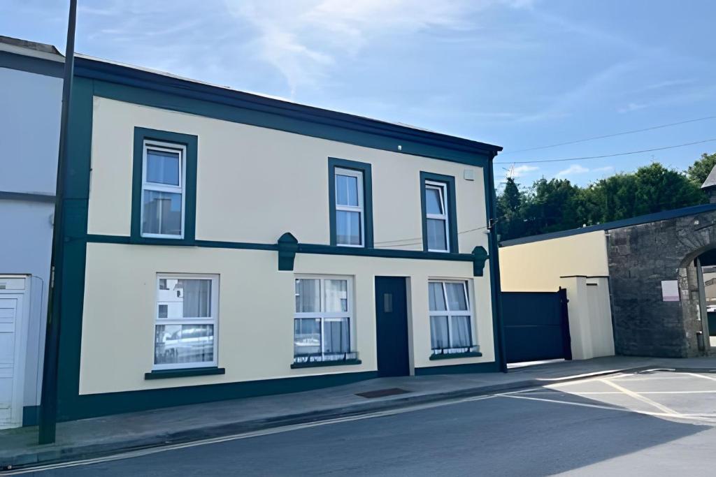 a white building with a black roof at The Old Post Office Holiday Home, Dunmore in Galway