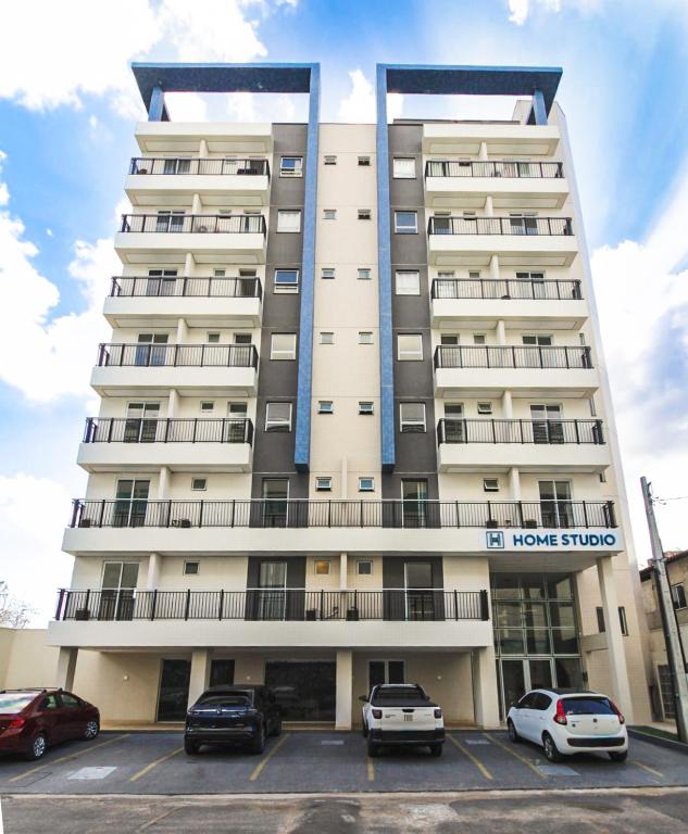 a tall building with cars parked in a parking lot at Home Studio in Sobral