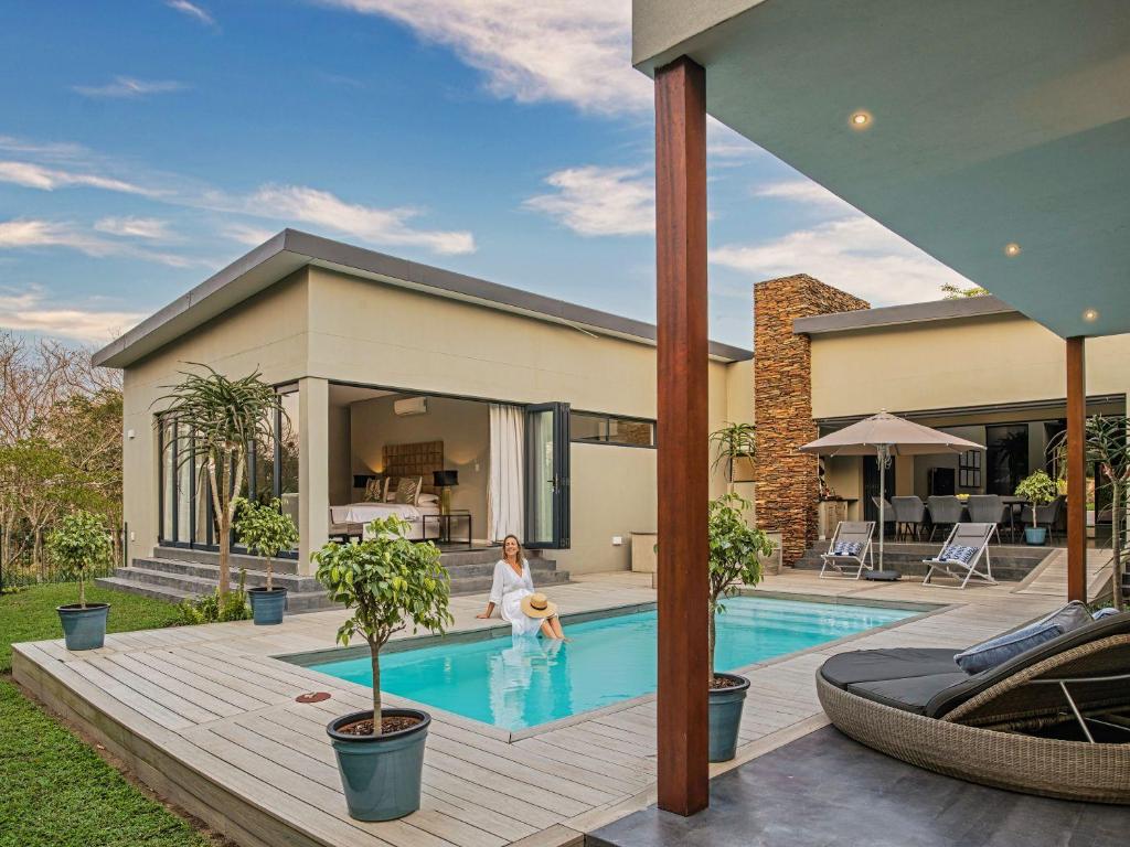 a woman is in the swimming pool of a house at Luxury Villa Rainbow, Eden Rock Estate, Pennington in Pennington