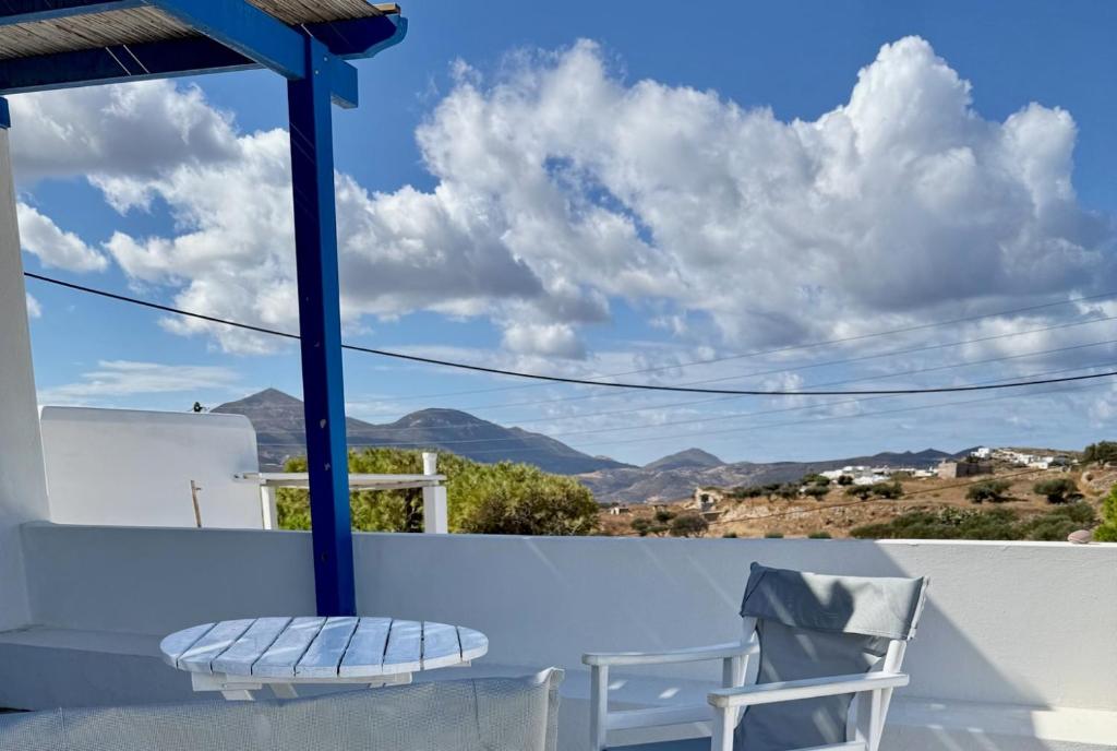 a chair on a balcony with a view of mountains at Peaceful Cycladic Studio with Large Terrace & View in Tripiti
