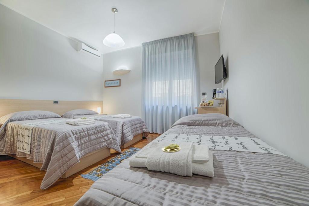 a bedroom with two beds and a tv at B&B Studio 162 in Bari