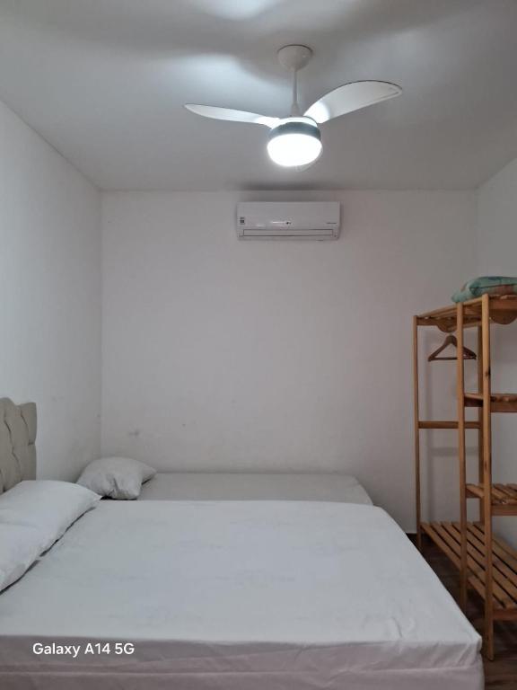 a bedroom with a bed with a ceiling fan at Casa em Prado bahia in Prado