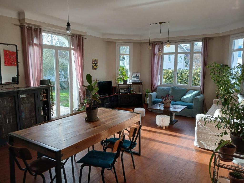 a living room with a wooden table and chairs at La Jarria in Jurançon