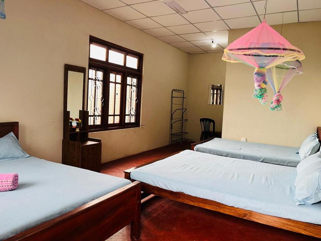 a room with two beds and a kite hanging from the ceiling at Ranathunga Guest Kataragama in Kataragama