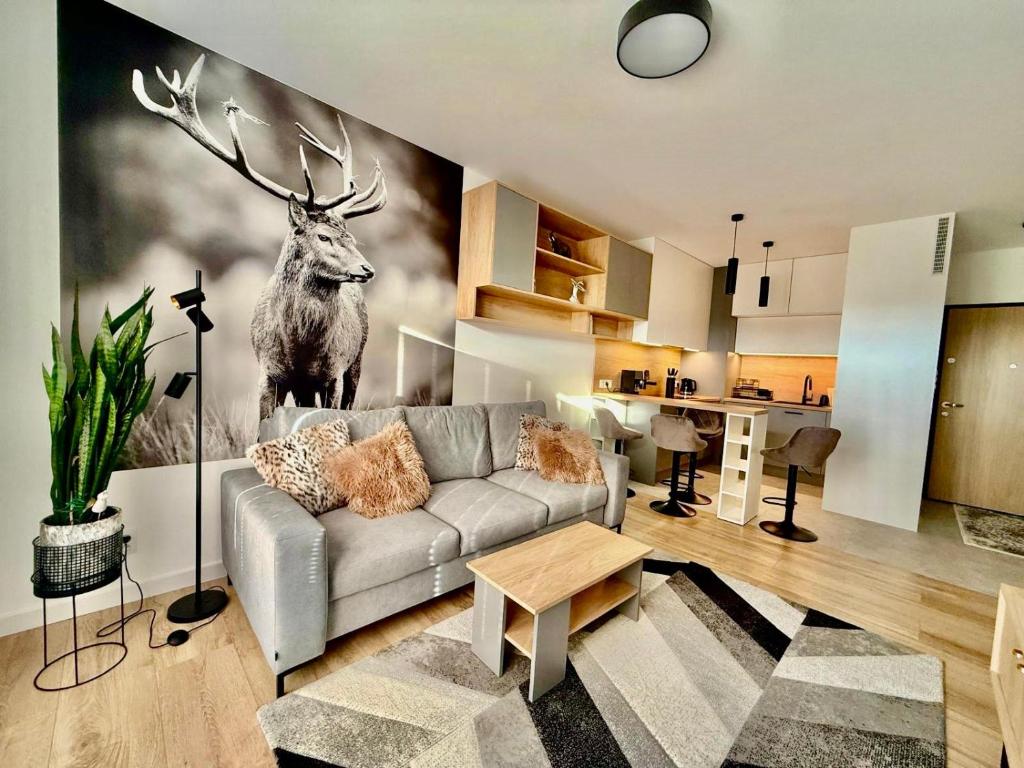a living room with a painting of a deer on the wall at Jarzebinowa Loft by JumpInHere in Nowy Dwór Mazowiecki