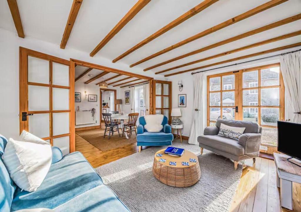 a living room with a blue couch and chairs at Charming Family Stables Conversion - Pass the Keys in Emsworth
