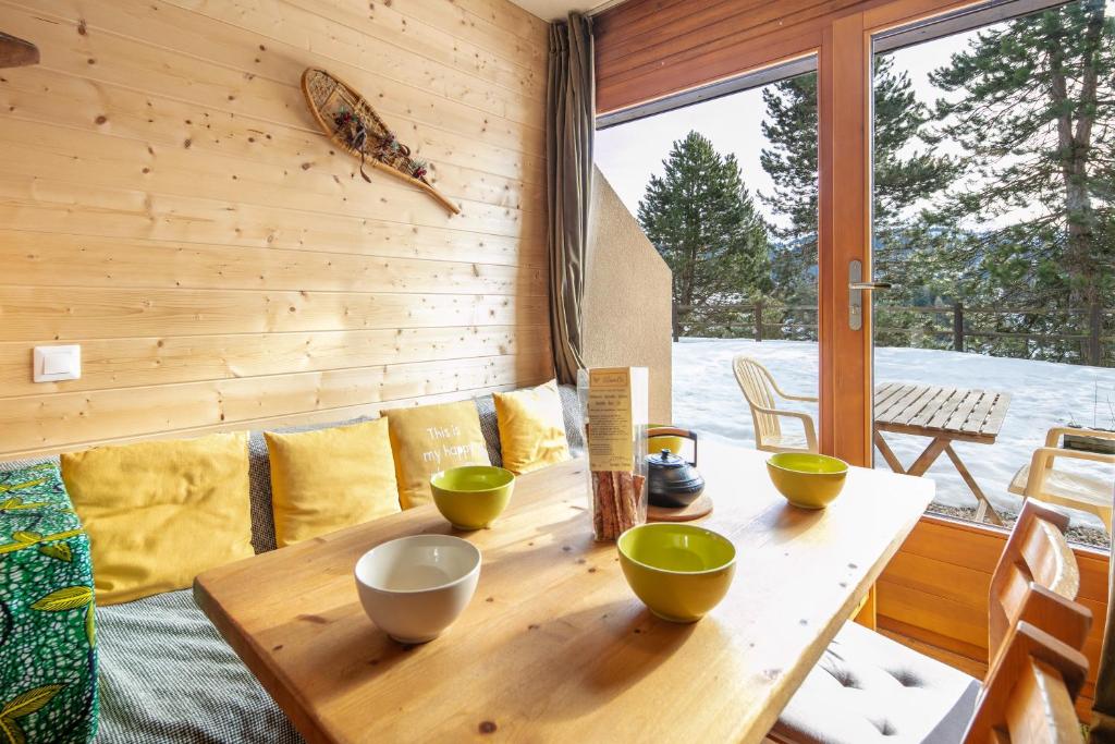 a wooden table with bowls on it in a room at Le Martagon - Proche Station de Ski in Gresse-en-Vercors