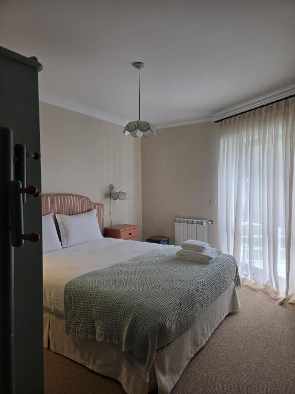 a bedroom with a large bed and a window at Villa Casa do Canal in Apúlia