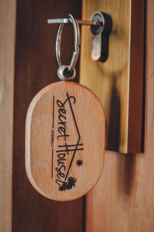 a key tag on a wooden door with the word entrance at Secret House in Dickwella