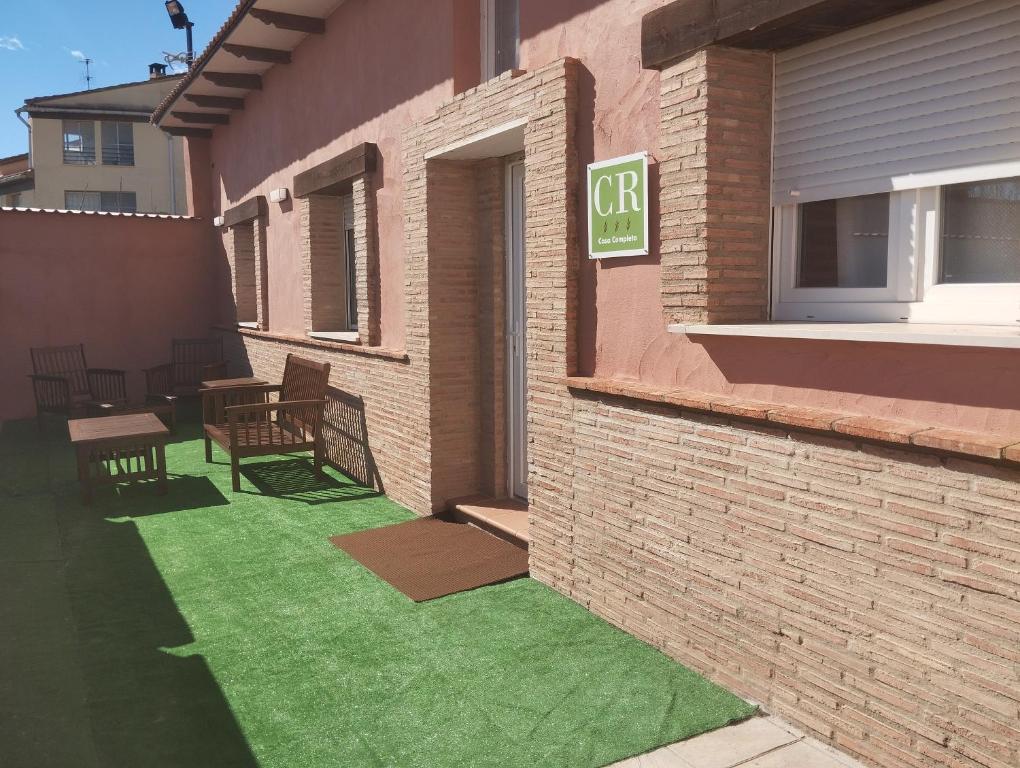 a patio with green grass outside of a building at Casa rural El Terreno in Teruel