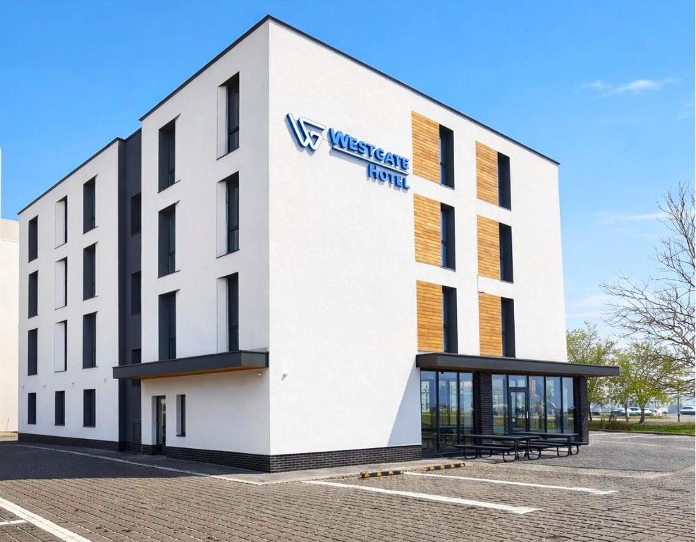 a white building with a sign on the side of it at WESTGATE Hotel - FREE PARKING in Veliko Tŭrnovo