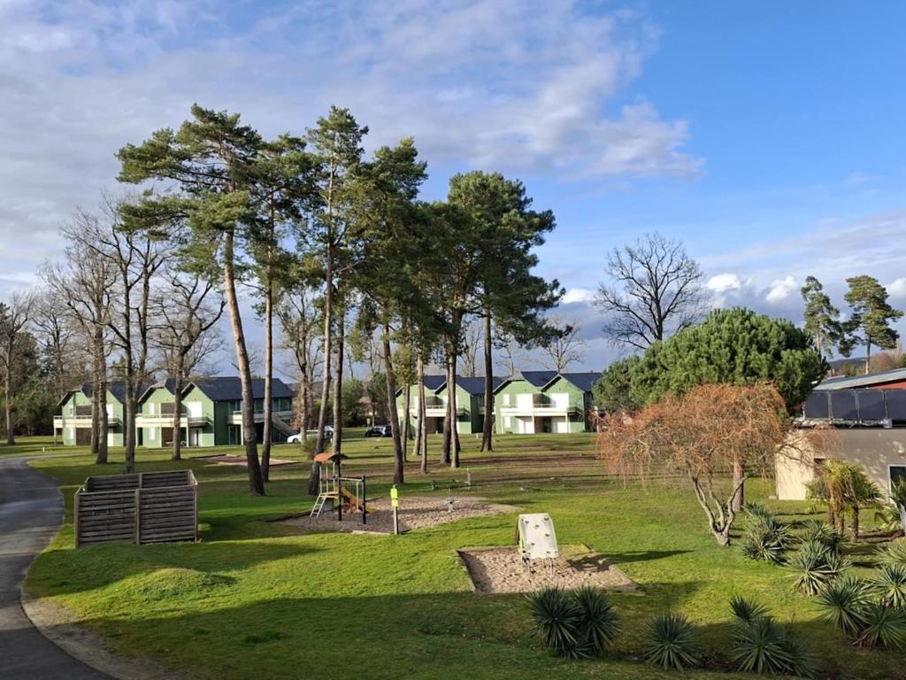a park with trees and houses in the background at cottage poussin 12 picine lave linge in Chaveignes