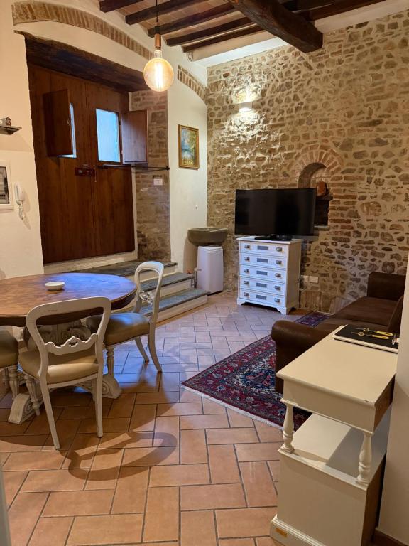 a living room with a table and a tv at Dimora dei cesari in Città di Castello