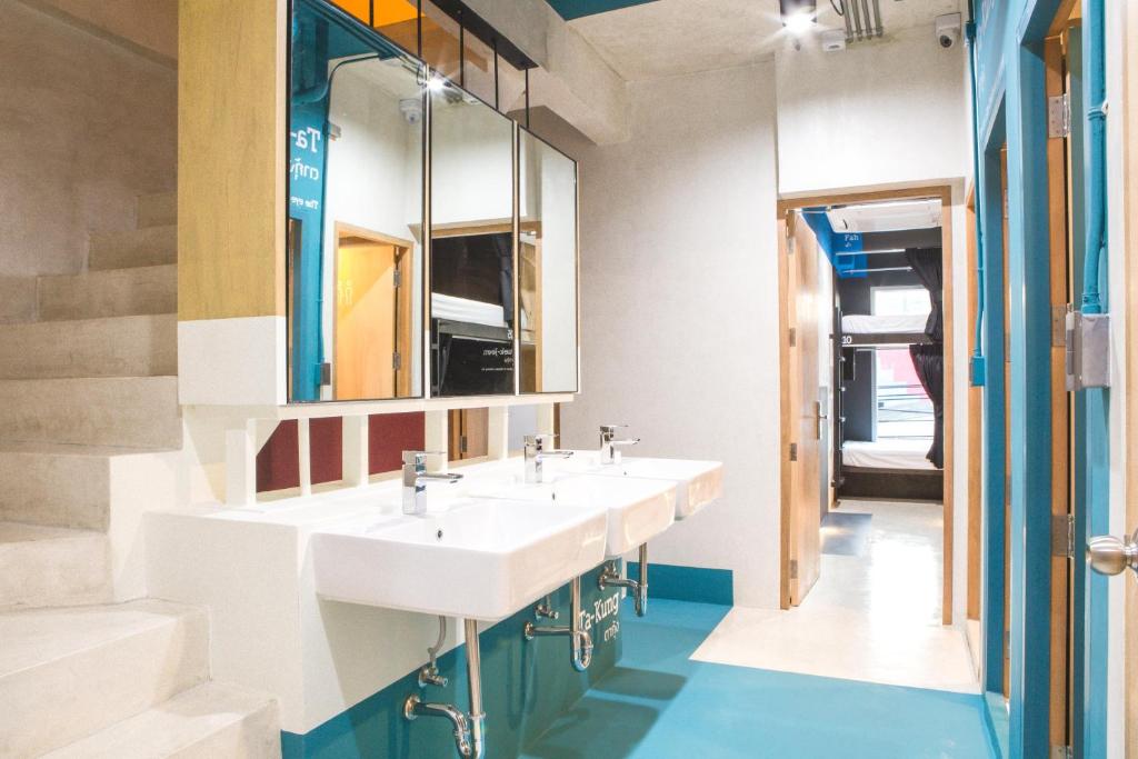 a bathroom with two sinks and a mirror at The BoB Hostel in Bangkok
