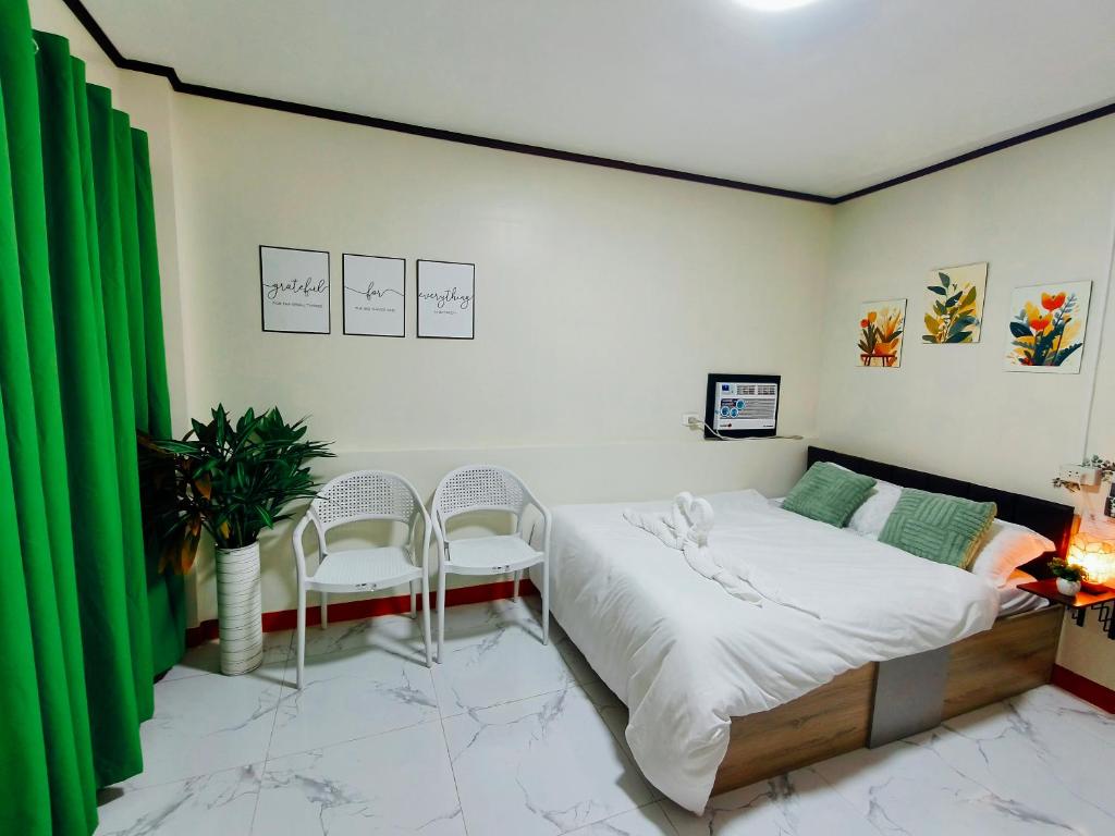 a bedroom with a bed and two chairs at G & B Transient House in San Jose