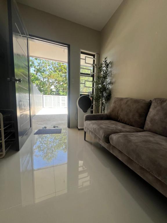 a living room with a couch and a glass table at Hayat Apartment Digos City in Dawis