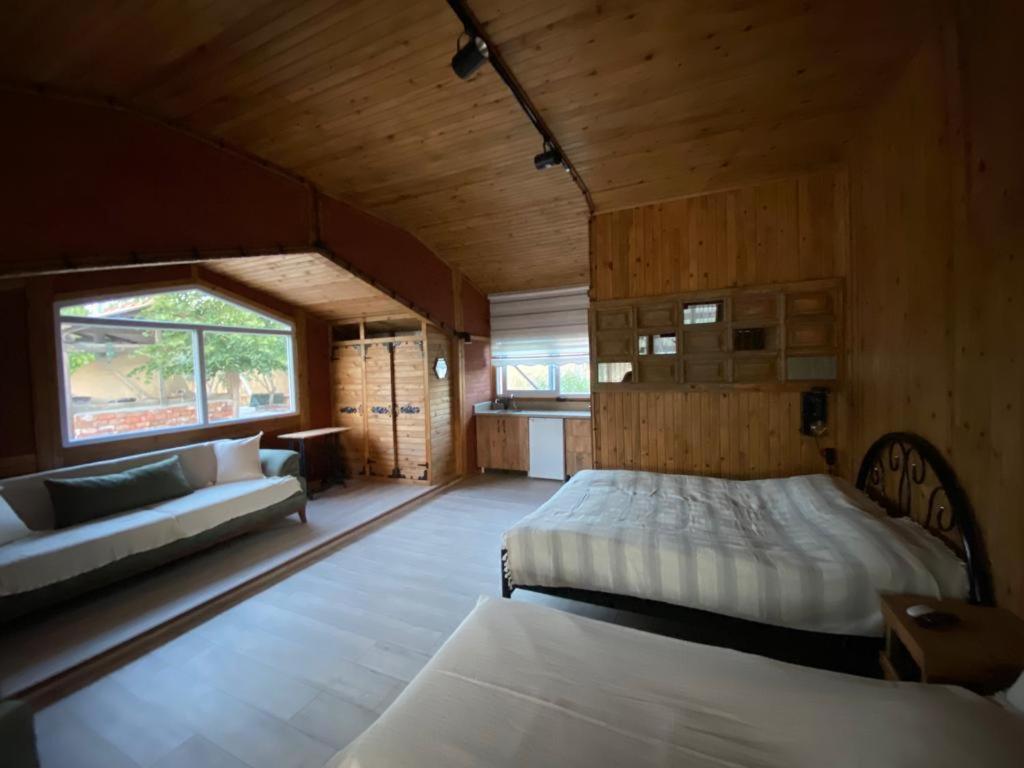 a bedroom with two beds and a couch in a room at CasaMora in Edremit