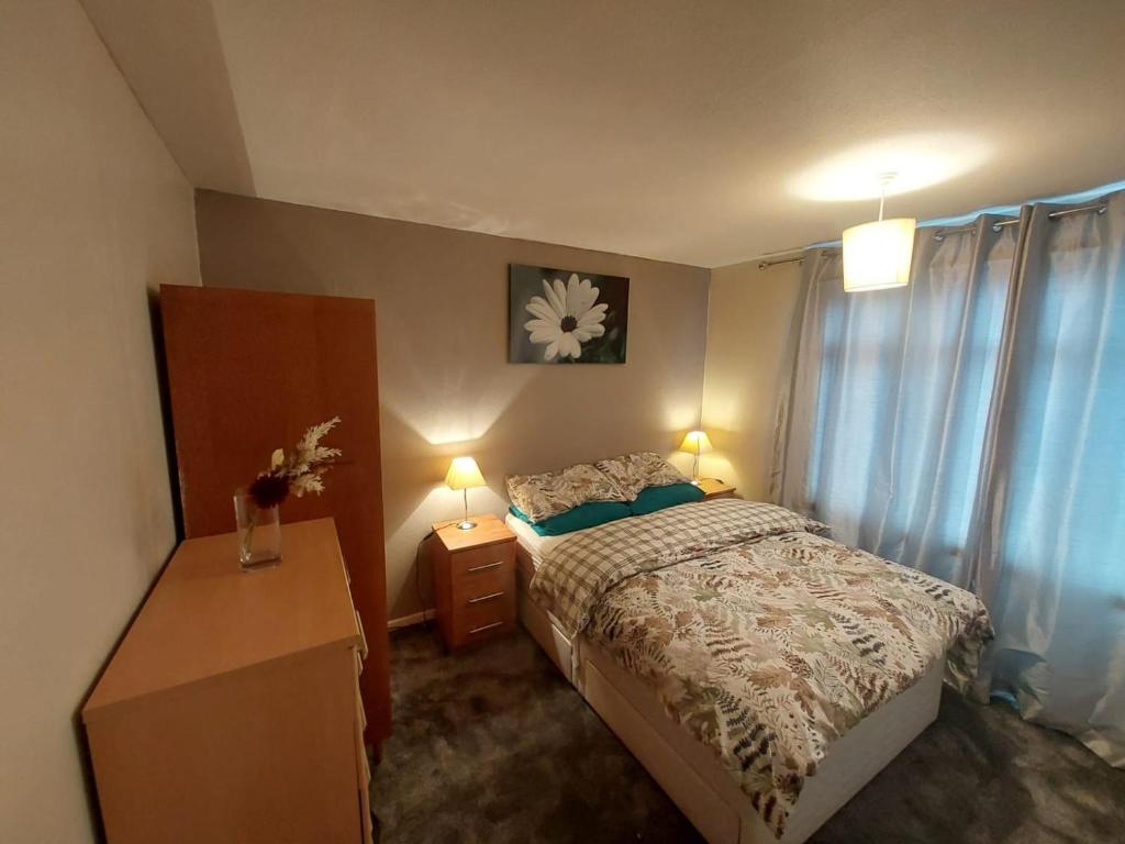 a bedroom with a bed and a dresser and two lamps at Private Home Grays in Orsett
