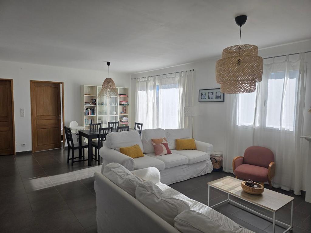 a living room with a white couch and a table at maison être mer et montagne in Ponte-Leccia