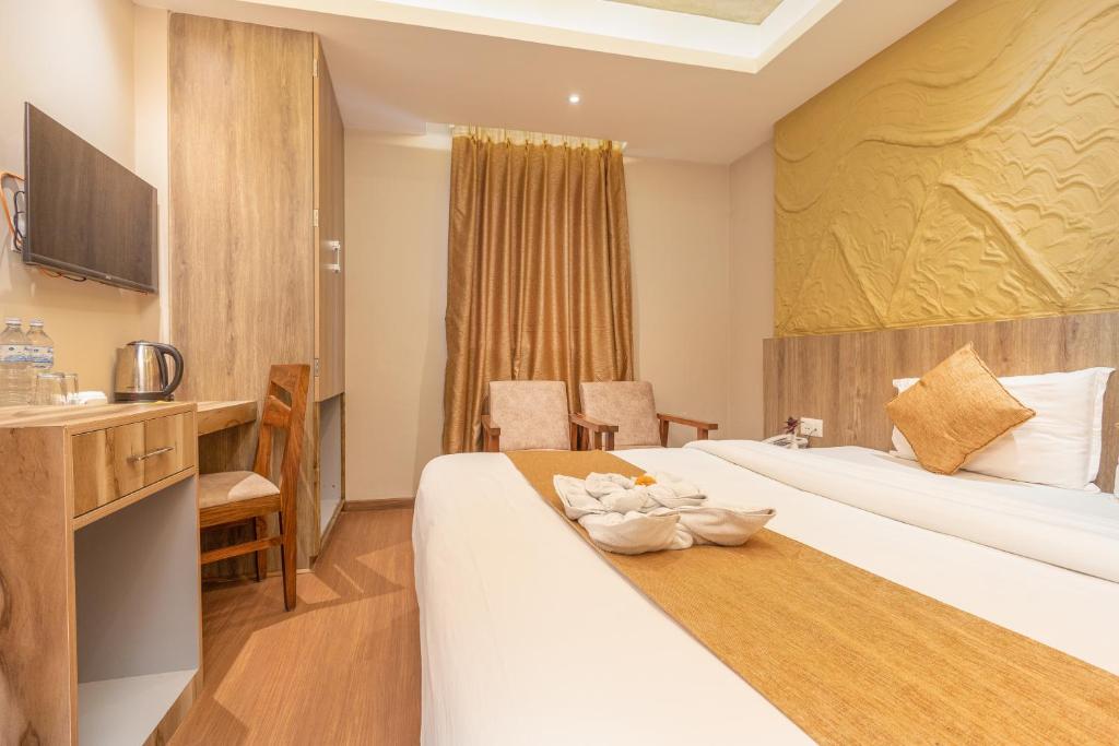 a hotel room with two beds and a desk at Divya Boutique Inn in Kathmandu