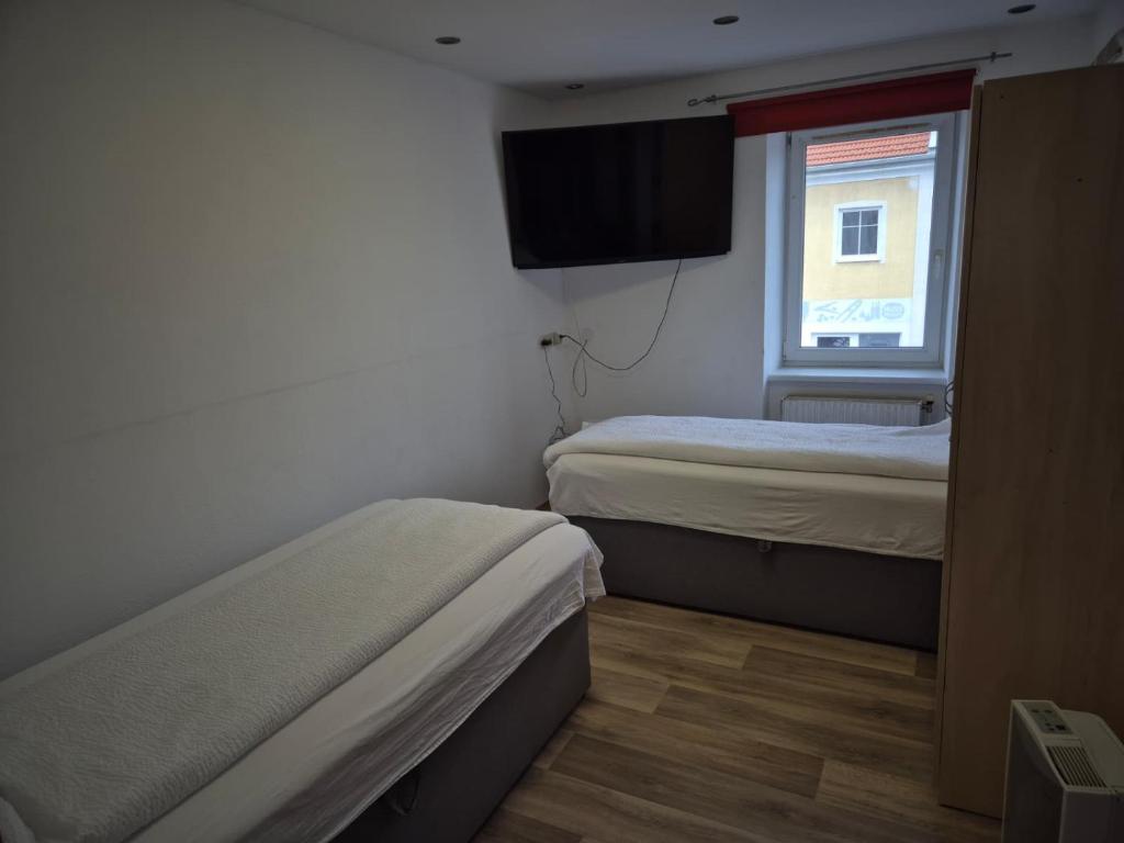 a small room with two beds and a window at Apartment Krummnußbaum, Donau & Wachau in Krumnussbaum an der Donauuferbahn