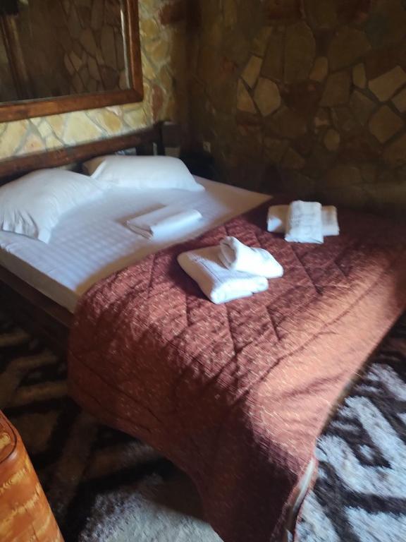 a bedroom with a bed with towels on it at Kalavrita Mons in Kalavrita