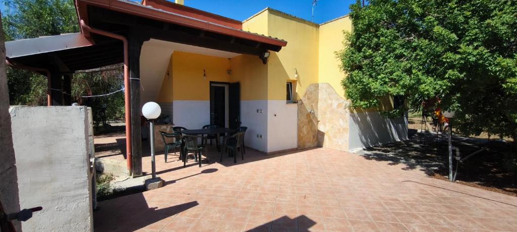 a patio of a house with a table and chairs at Cascina Vittorio, Relax in campagna con barbecue vicino Gallipoli in Noha