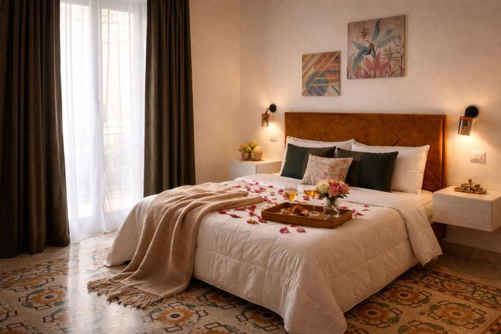 a bedroom with a bed with a tray of flowers on it at Terra d'amuri Rooms in Terrasini