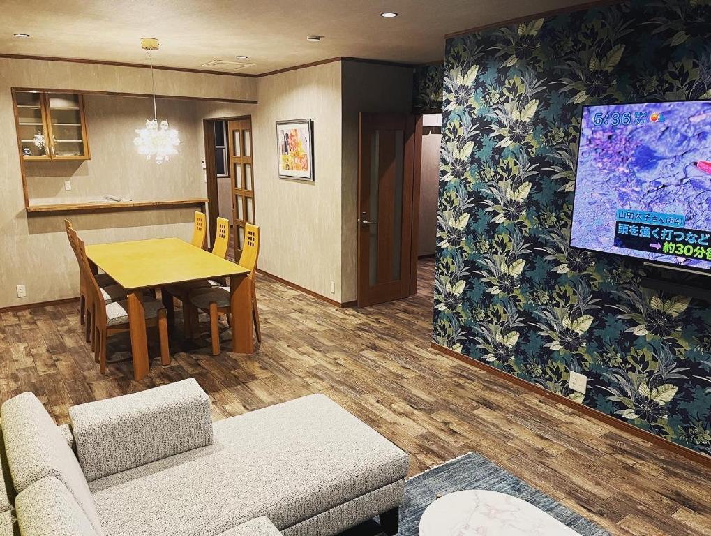 a living room with a table and a tv at 安全な個室貸切に広々した共用スペースの喜久屋コテージクレア in Yamanakako