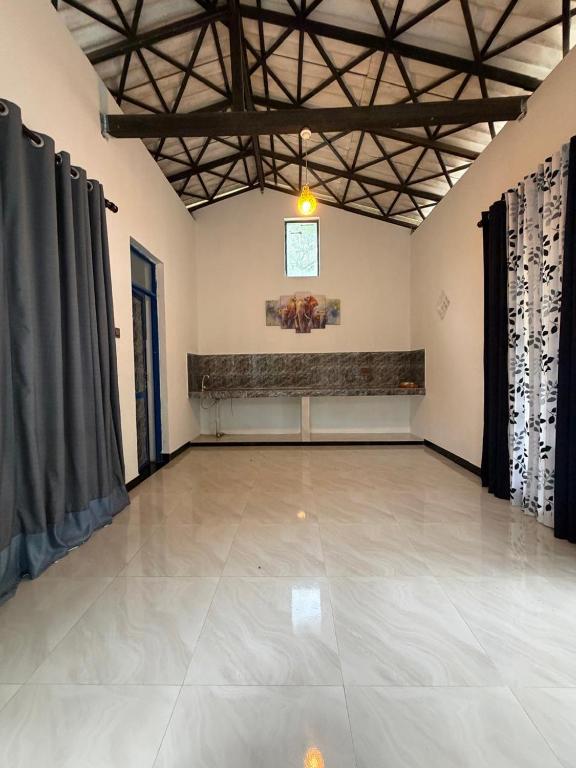 a large room with a large tile floor and curtains at Peacock grand resort in Kataragama