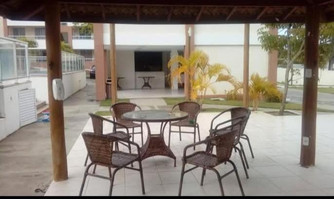 a patio with a table and chairs on a patio at Dunas de Guarajuba in Camacari