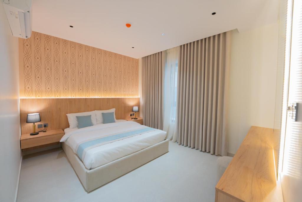 a bedroom with a large bed and two night stands at Luxury & Modern Brand New Family Apartments in Medina
