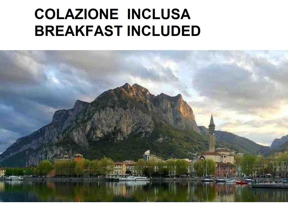a mountain in front of a body of water with a town at La nostra casa in centro in Lecco