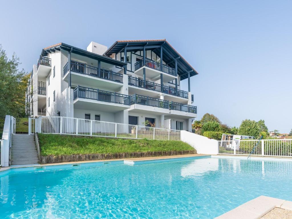 an apartment building with a swimming pool in front of it at Apartment Kantaldi-2 by Interhome in Guéthary