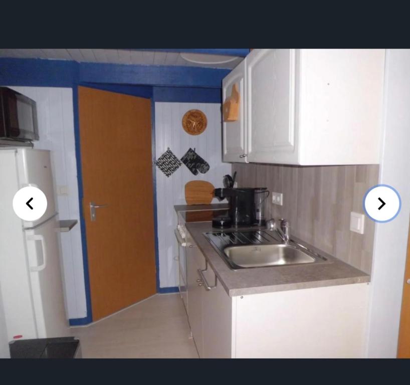 a small kitchen with a sink and a refrigerator at Haus Glück Auf in Dornumergrode