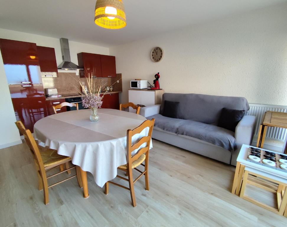 una sala de estar con una mesa y un sofá en Terre-Mer, en Fort-Mahon-Plage