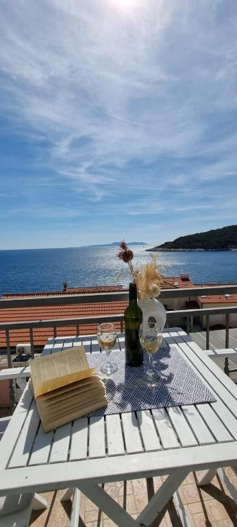 a white picnic table with a bottle of wine and glasses at Matea Apartments Milna in Milna