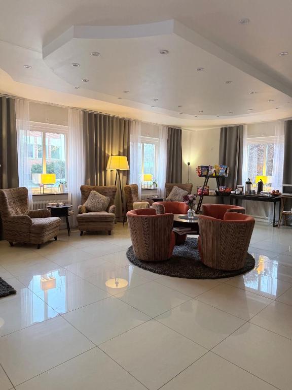 a large living room with chairs and a table at Kungsbacken Hotell & Konferens in Katrineholm