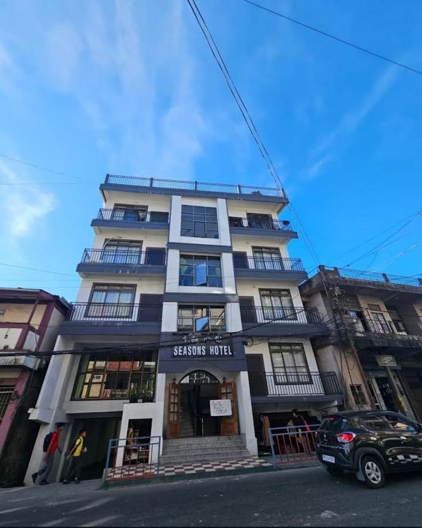 a building on a street with a car parked in front at Seasons Hotel in Lunglei