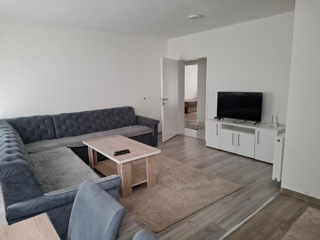 a living room with a couch and a television at Apartman Iva in Foča