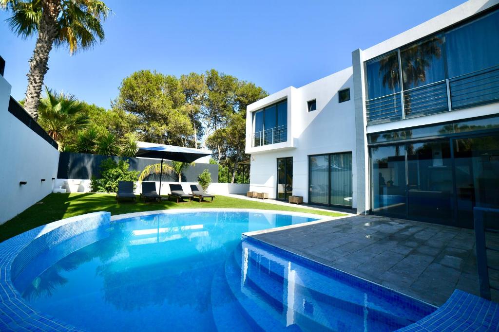 a swimming pool in front of a house at Villa Alvor in Alvor