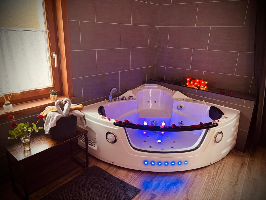 a bathroom with a bath tub in a room at Maison NidAmour Val-de-Travers in Saint-Sulpice