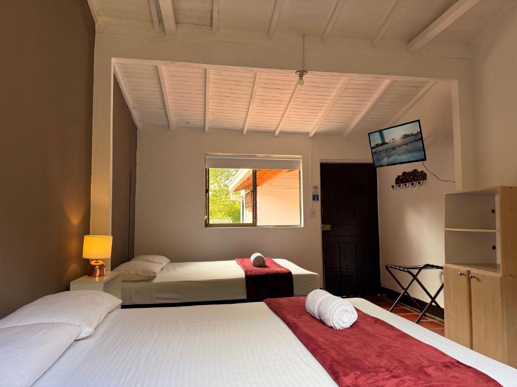 a bedroom with two beds and a window at Hotel CSI Llanogrande in Rionegro