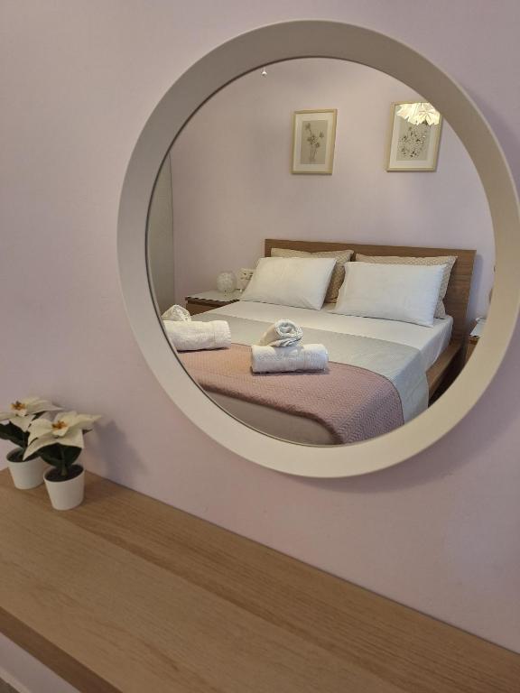 a bedroom with a large circular mirror on the wall at B&B one in Vonitsa