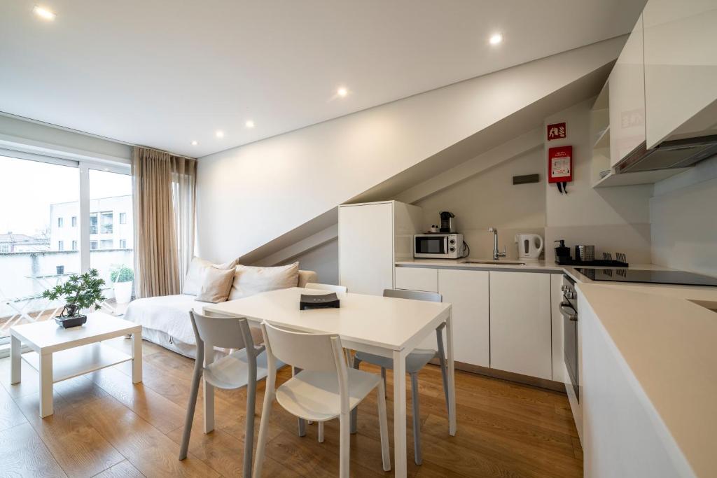a kitchen and living room with a table and chairs at Terro Collection - Alcaide in Braga
