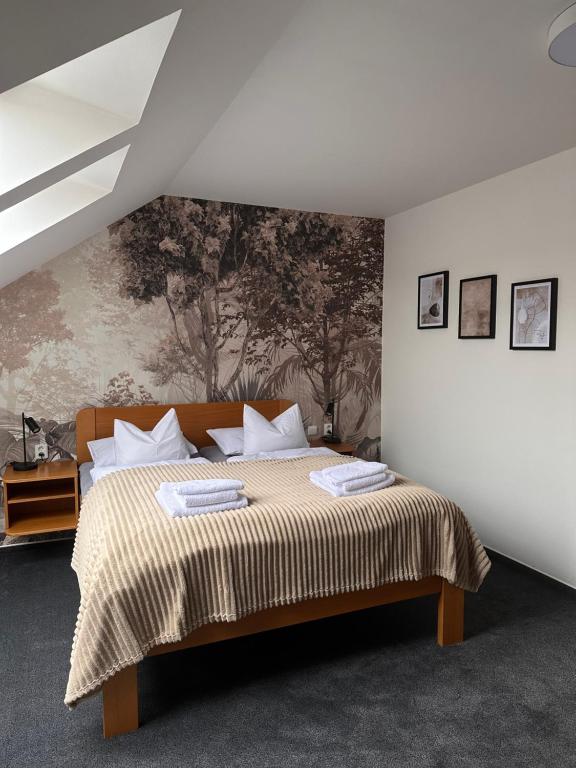 a bedroom with a bed with a painting on the wall at Penzion Luna in Brno