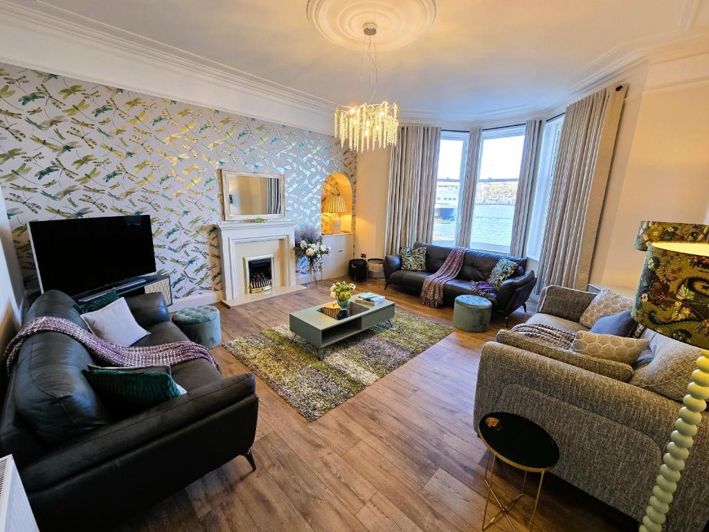 a living room with couches and a fireplace at The Harbour House - Deluxe Town Centre Property in Rothesay